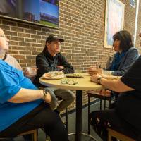 President Mantella talking with families seated inside Kirkhof Center during pancake breakfast.